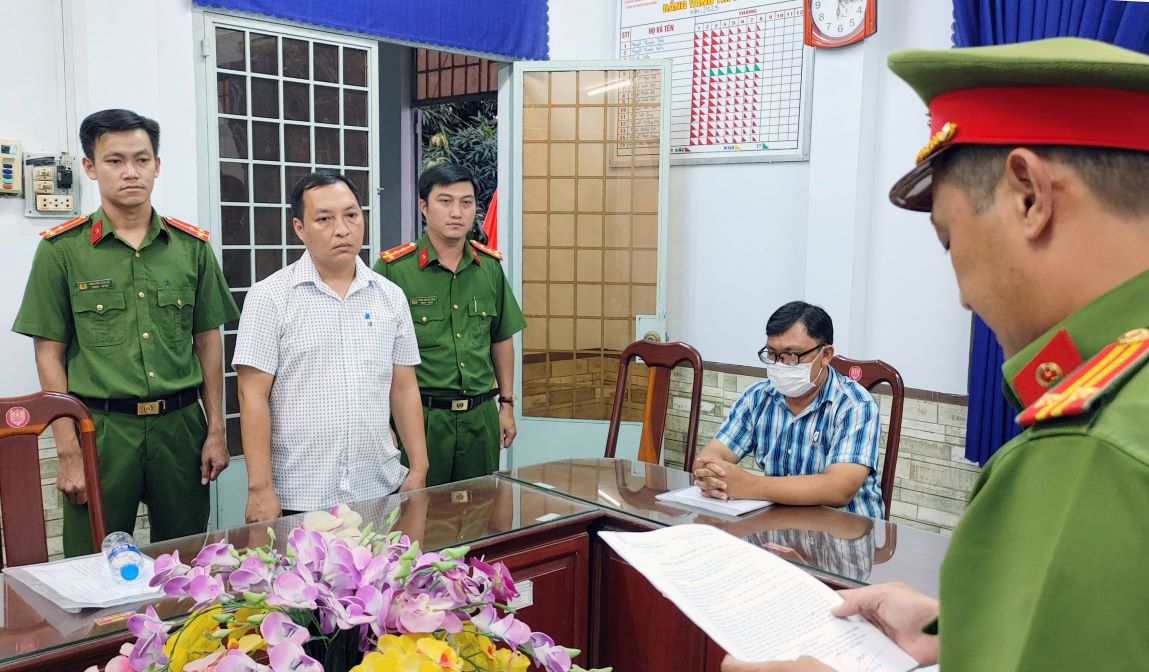 Cơ quan Công an đang tống đạt các quyết định khởi tố, bắt giam đối với bị can Ngô Hồng Việt Chương ( thứ 2 từ trái sang). Ảnh: Vũ Tiến 