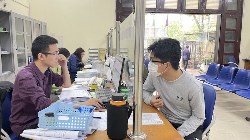 Cán bộ BHXH Việt Nam tư vấn cho người lao động về thủ tục BHXH bắt buộc. Ảnh: Hà Anh