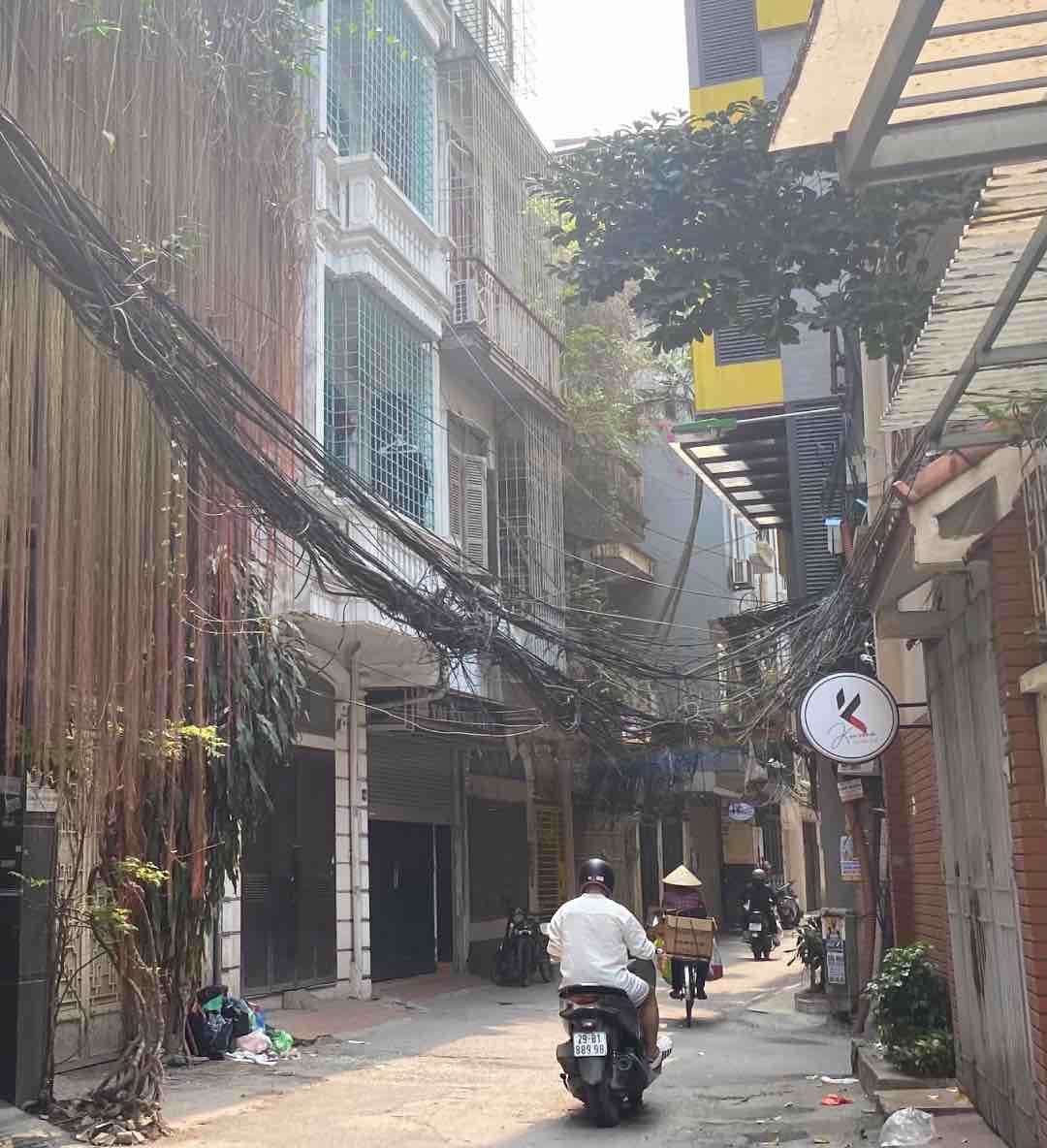 Một đoạn búi điện sà xuống gần sát với người đi đường trong ngõ Nguyễn Phúc Lai. Ảnh: Vân Anh