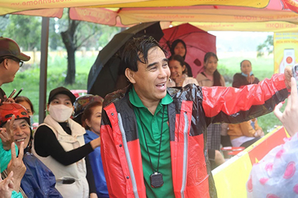 Quyền Linh đội mưa khi làm MC một chương trình tổ chức cho người lao động có hoàn cảnh khó khăn. Ảnh: Nhân vật cung cấp