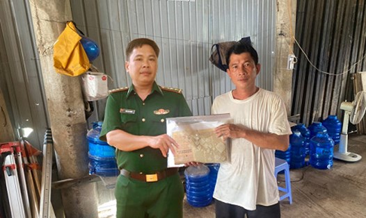 Thượng úy Ngôn Văn Thuận trao trả tập hồ sơ cho anh Nguyễn Văn Phong. Ảnh: Kiên Quyết