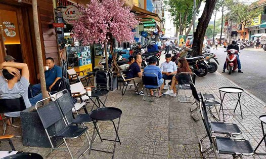 Vỉa hè đường Huỳnh Thúc Kháng (Quận 1) bị quán cà phê chiếm dụng để bày bàn ghế cho khách ngồi.  Ảnh: Minh Quân