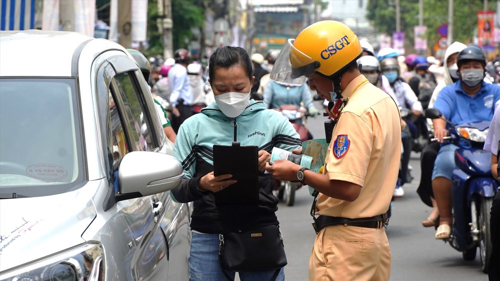 Công an quận Ninh Kiều (TP Cần Thơ) xử lý các trường hợp lái ô tô đi vào khung giờ cấm để đón con. Ảnh: Tạ Quang