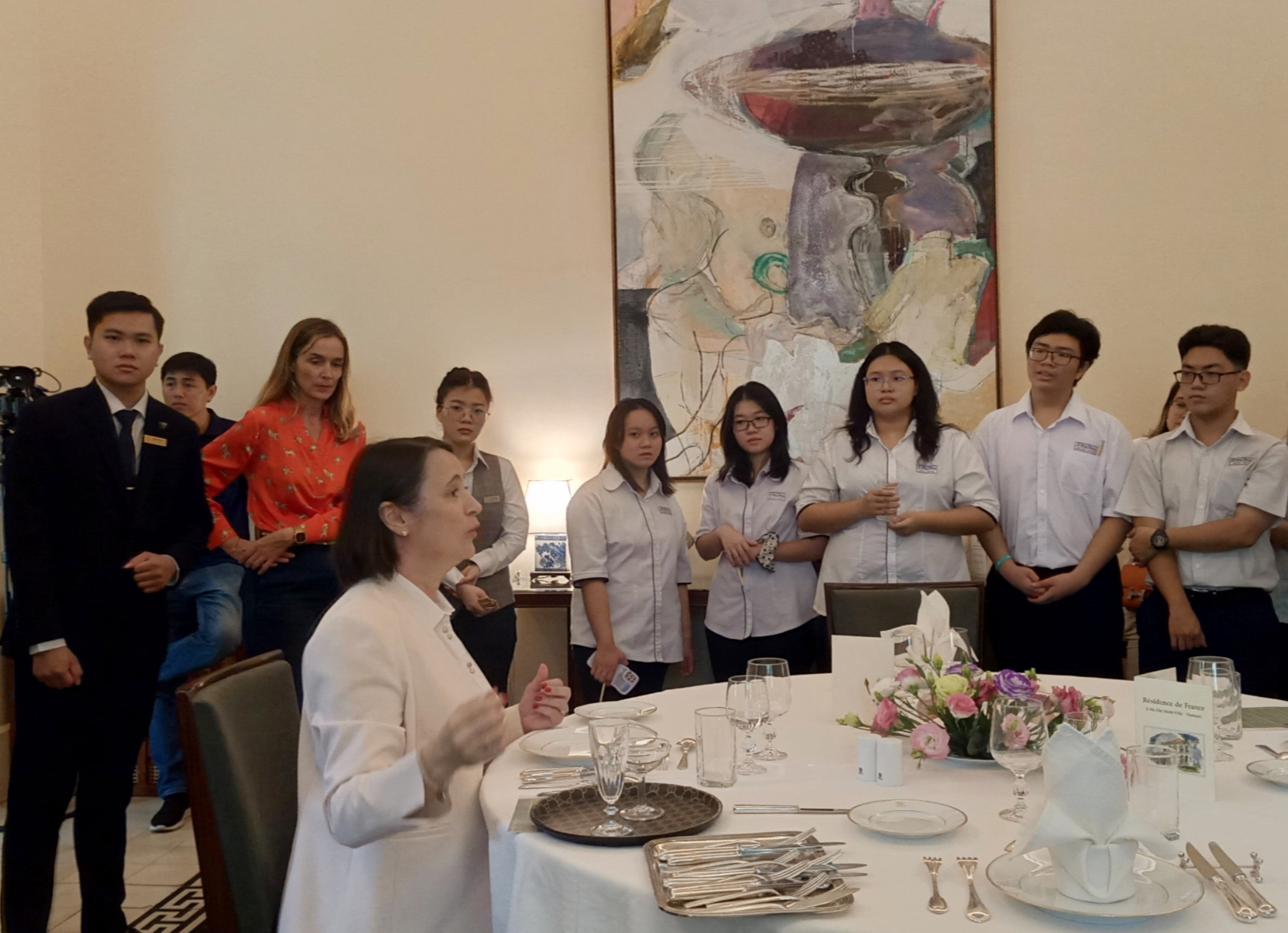 Bà Emmanuelle Pavillon-Grosser - Tổng lãnh sự Pháp tại TPHCM cùng với đội ngũ nhân viên Hotel des Art Saigon - M Gallery Collectin dạy quy tắc bàn ăn kiểu pháp cho các bạn học sinh. Ảnh: Vi Vi.