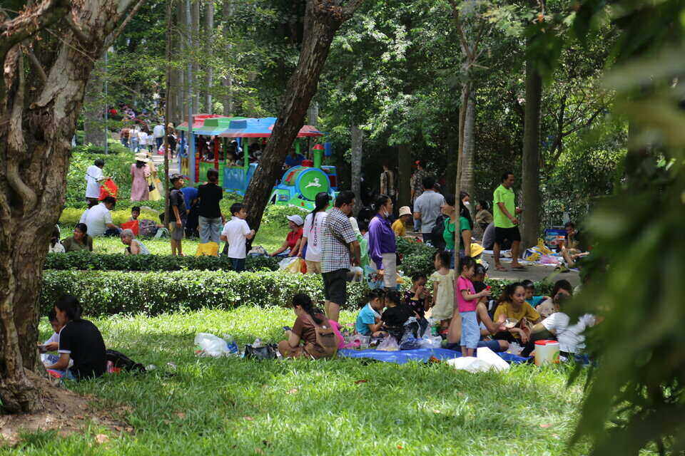 Nhiều du khách mang theo bạt, tấm trải để tranh thủ nghỉ trưa dưới những tán cây. Các gốc cây lớn, thảm cỏ thành nơi nghỉ ngơi, ăn uống của du khách.