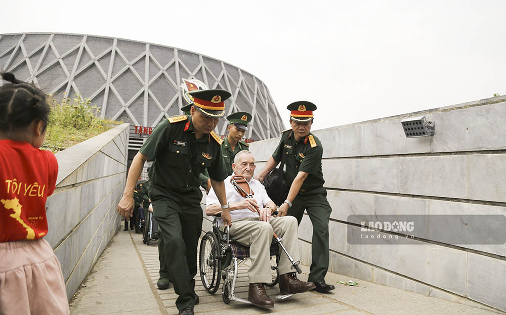 Một cựu binh pháp đã hơn 90 tuổi được các anh bộ đội Việt Nam hỗ trợ di chuyển tham quan các hiện vật chiến tranh tại Bảo tàng Chiến thắng Điện Biên Phủ.