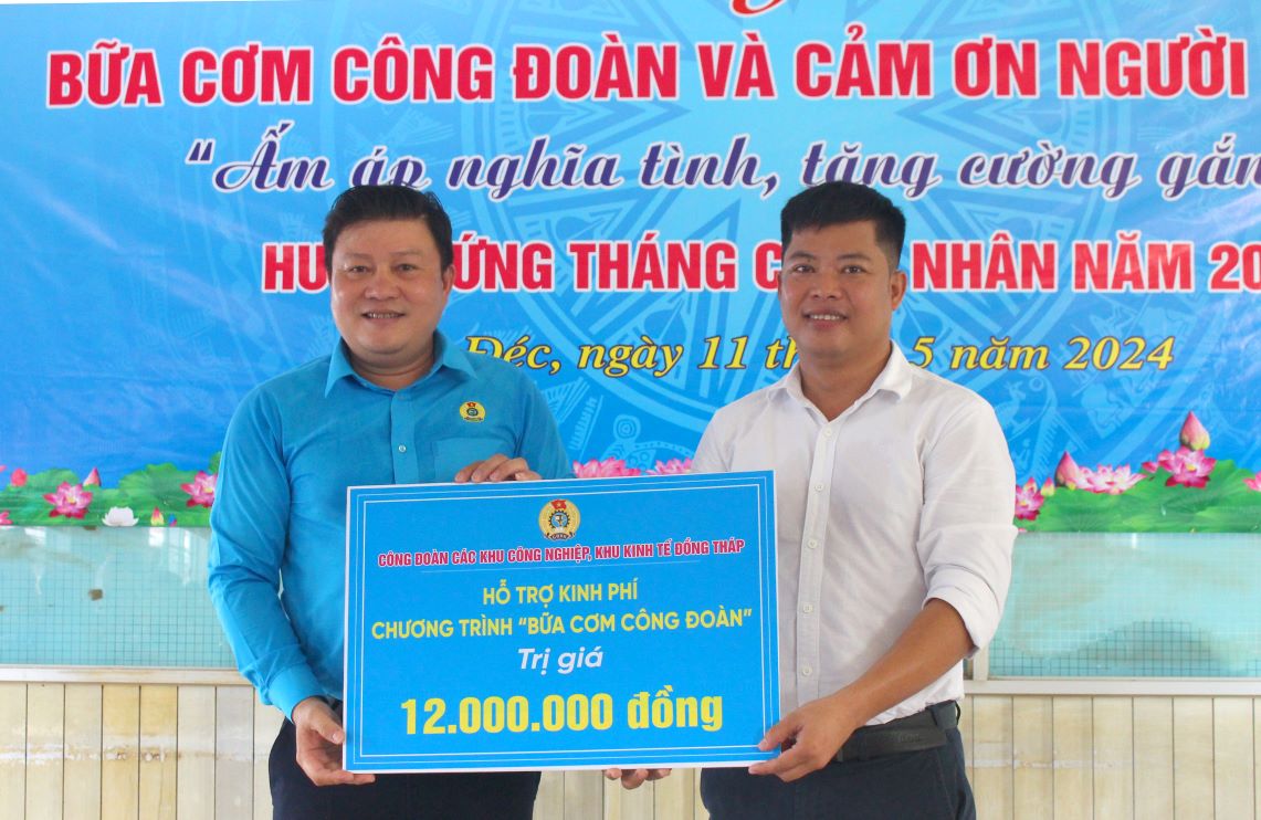 Ông Nguyễn Thanh Nhàn - Chủ tịch Công đoàn các khu công nghiệp, khu kinh tế Đồng Tháp trao biển tượng trưng số tiền hỗ trợ cho ông Lý Trọng Khang- Chủ tịch CĐCS Công ty Cổ  phần chế biến và xuất nhập khẩu thuỷ sản Cadovimex II. Ảnh: Thanh Nhàn  