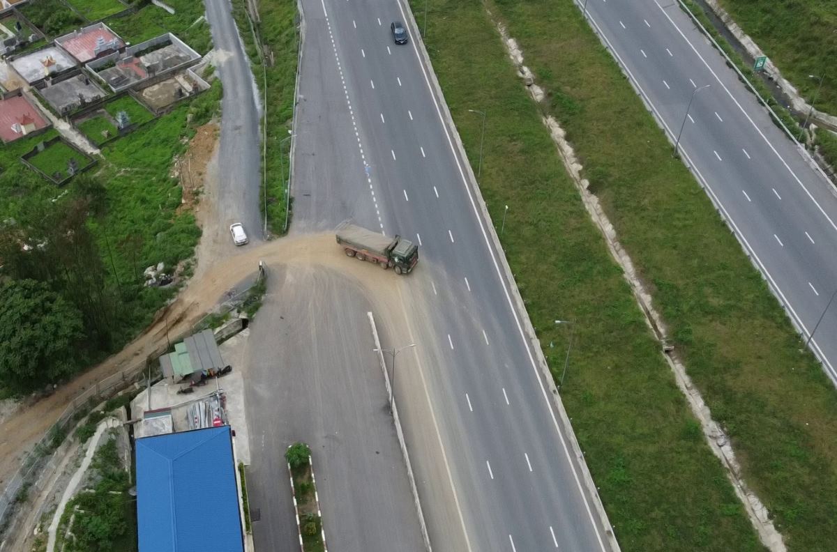 Những chiếc xe tải chở đất chạy cắt ngang đường cao tốc (đoạn trước cửa hầm Thung Thi, ở xã Hà Lĩnh, huyện Hà Trung, Thanh Hóa). Ảnh: Minh Hoàng