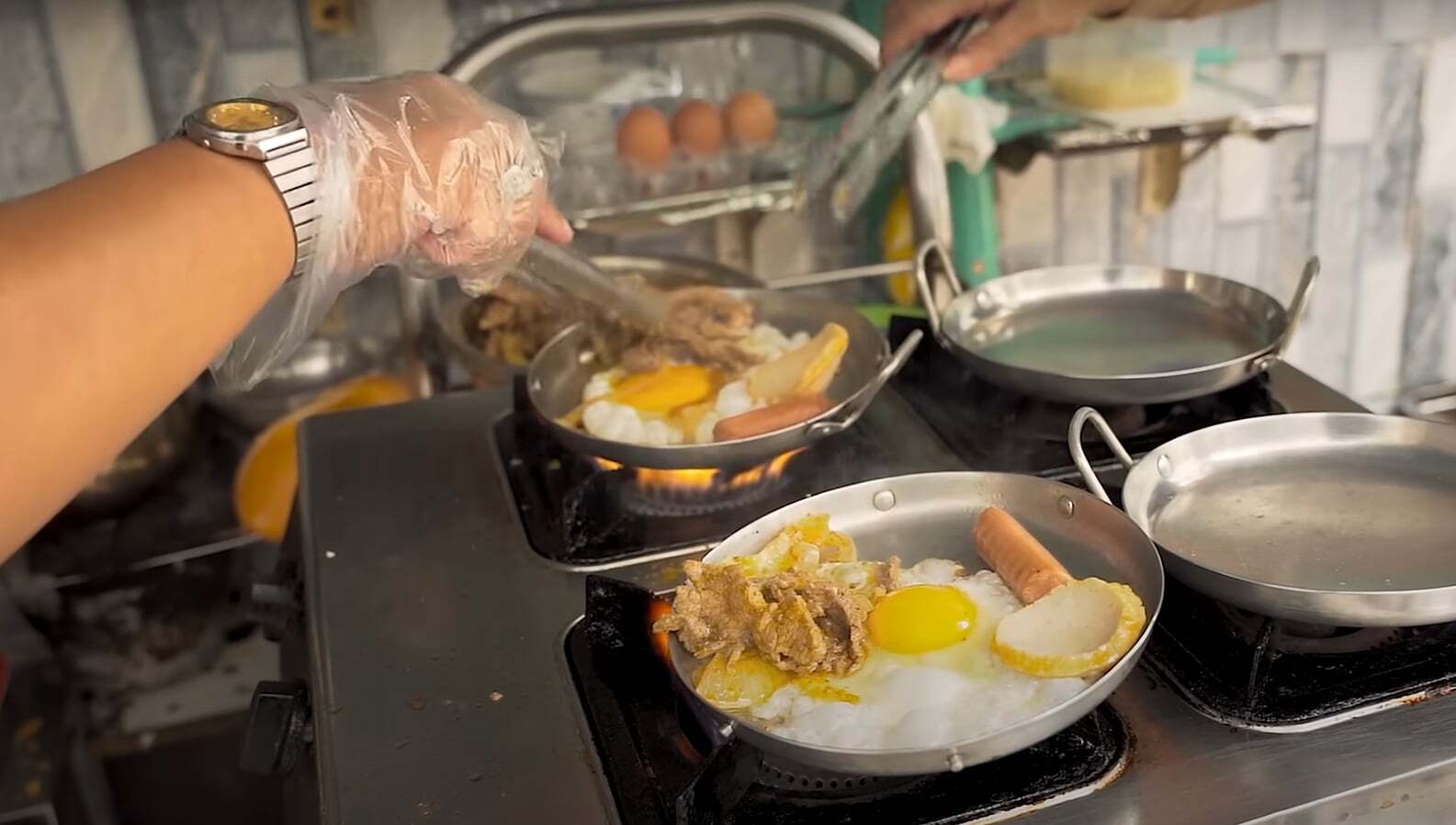 Những chảo bánh mì được nấu ngay ở cửa quán, thực khách có thể thấy cách chủ quán chế biến suất ăn cho mình. Ảnh: cắt từ video