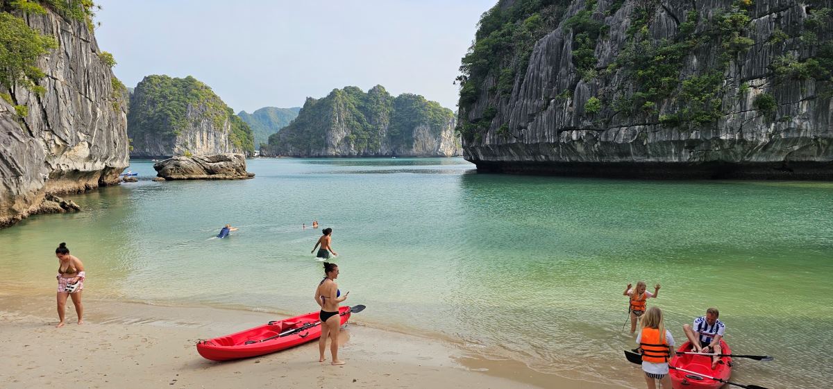 Du khách quốc tế chèo kayak từ tàu du lịch vào một bãi cát giữa vịnh Lan Hạ, Hải Phòng. Ảnh: Nguyễn Hùng
