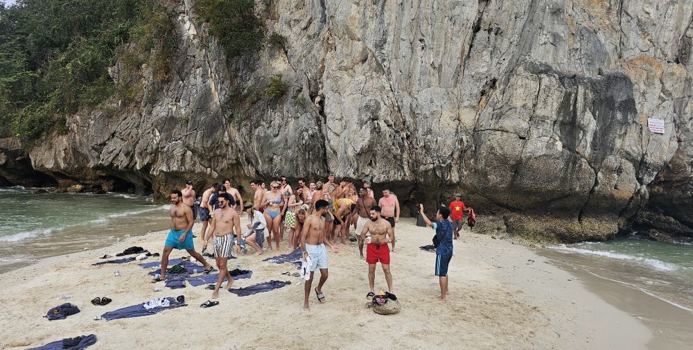 Du khách quốc tế ghé vào một bãi cát dưới chân núi giữa vịnh Lan Hạ, Cát Bà, Hải Phòng. Ảnh: Nguyễn Hùng