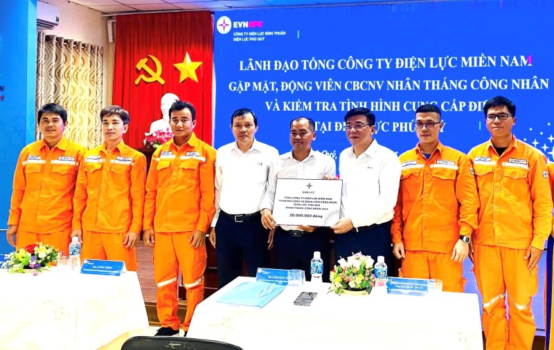 Ông Lê Văn Trang - Bí thư Đảng ủy, Chủ tịch HĐTV EVNSPC (thứ ba từ phải qua) và và ông Lê Xuân Thái - Chủ tịch Công đoàn EVNSPC  (thứ ba từ trái qua) tặng quà CNVCLĐ Điện lực Phú Quý. Ảnh: Đức Long

