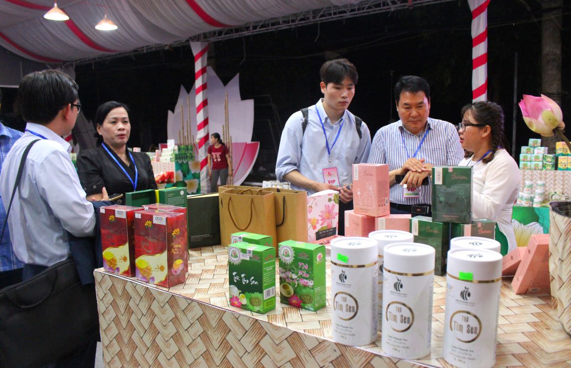 Ngay trong đêm khai mạc, tại không gian trưng bày sản phẩm từ sen, lãnh đạo Sở Công thương và doanh nghiệp Đồng Tháp hướng dẫn và kết nối giao thương sản phẩm sen với doanh nghiệp đến từ Hàn Quốc. Ảnh: Lâm Điền