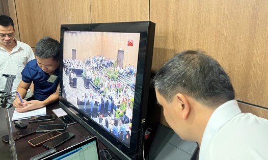 Phóng viên tác nghiệp tại một phiên tòa ở TAND Hà Nội ghi âm, ghi hình qua màn hình tivi. Ảnh: Quang Việt