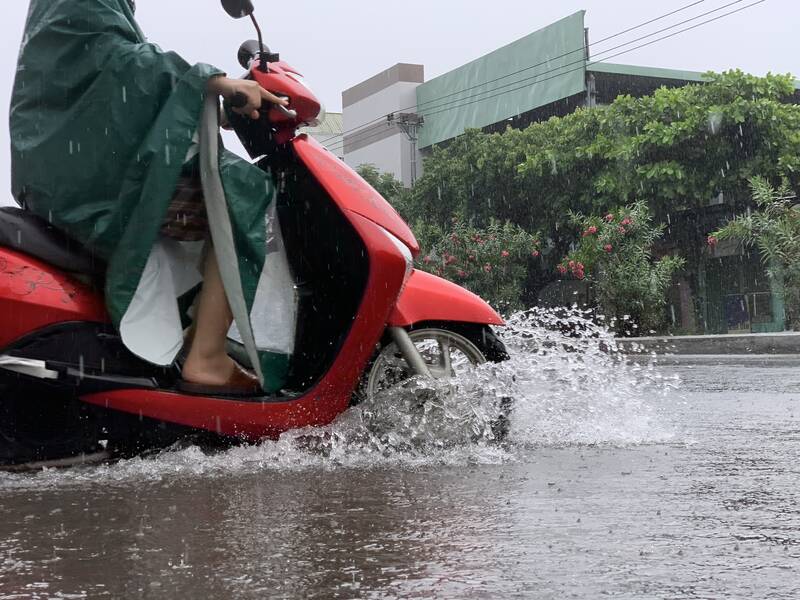 Mưa gây ngập nửa bánh xe của người dân. Ảnh: Nguyễn Linh