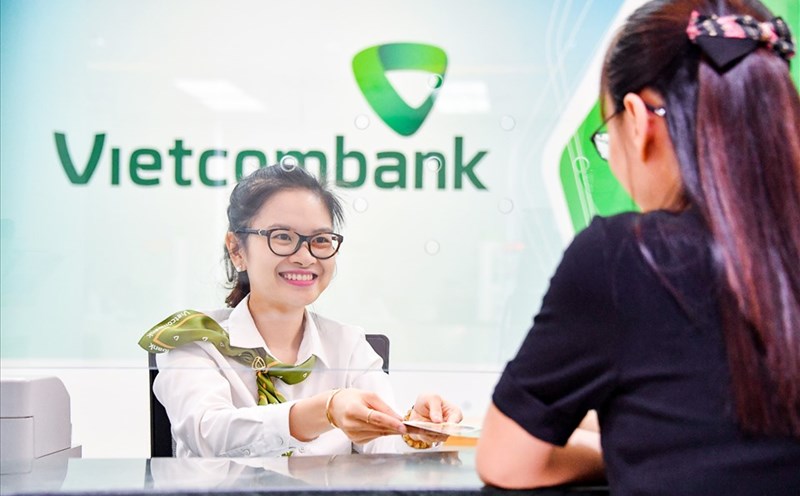 Nhân viên Ngân hàng Vietcombank thực hiện giao dịch với khách hàng bằng thái độ niềm nở, thân tình. Ảnh: L.D.O