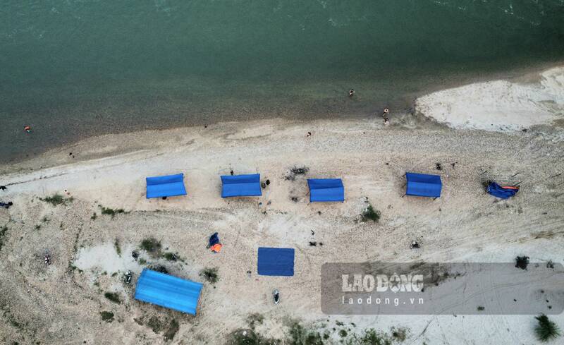 Thời điểm cuối tháng 4.2024, khu vực phía trên bờ, một số hộ dân dựng lều, bạt phục vụ nước nôi, ăn uống cho khách bơi sông. Ảnh: Lam Thanh