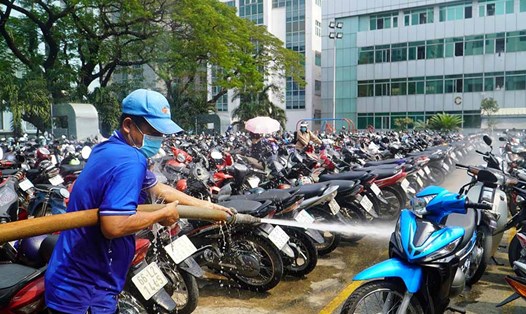 Không nên tưới nước lên xe máy sau khi di chuyển dưới trời nắng nóng. Ảnh: Minh Tâm