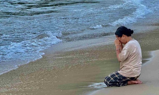 Mẹ cháu Lê Phước N quỳ khóc trên bờ biển chờ tin con mất tích. Ảnh: Nhật Hoàng.