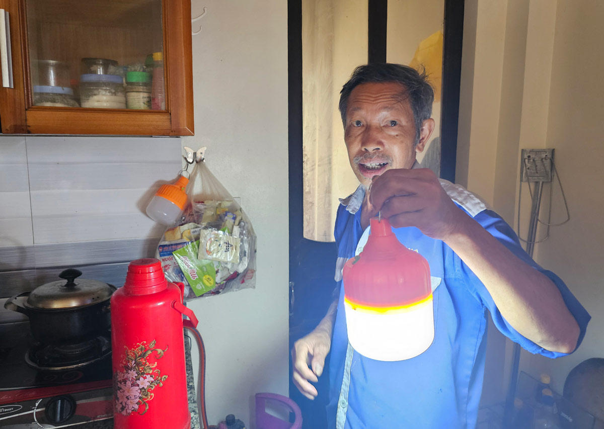 Ông Mạc Văn Đảo, thôn 1, xã Quảng Thịnh, huyện Hải Hà sạc điện cho các bóng đèn để dùng vào buổi tối khi điện yếu. Ảnh: Đoàn Hưng