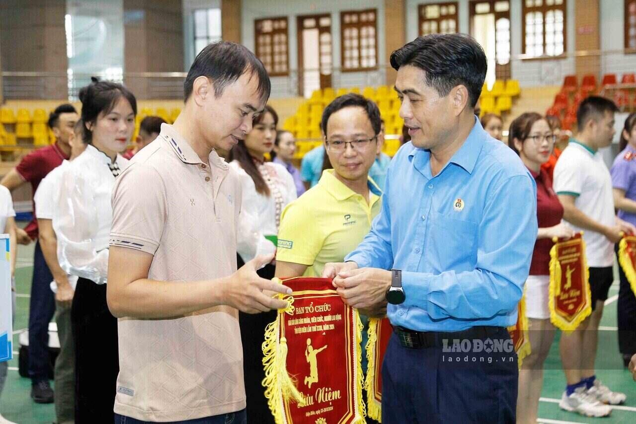 Ông Tẩn Minh Long (phải) - Chủ tịch LĐLĐ tỉnh Điện Biên tặng cờ lưu niệm cho các đoàn tham dự giải. Ảnh: Quang Đạt