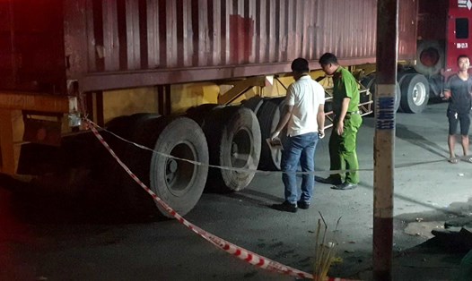 Công an khám nghiệm điều tra vụ nam thanh niên ngã vào bánh xe container đang ôm cua vào khu công nghiệp. Ảnh: Dương Bình