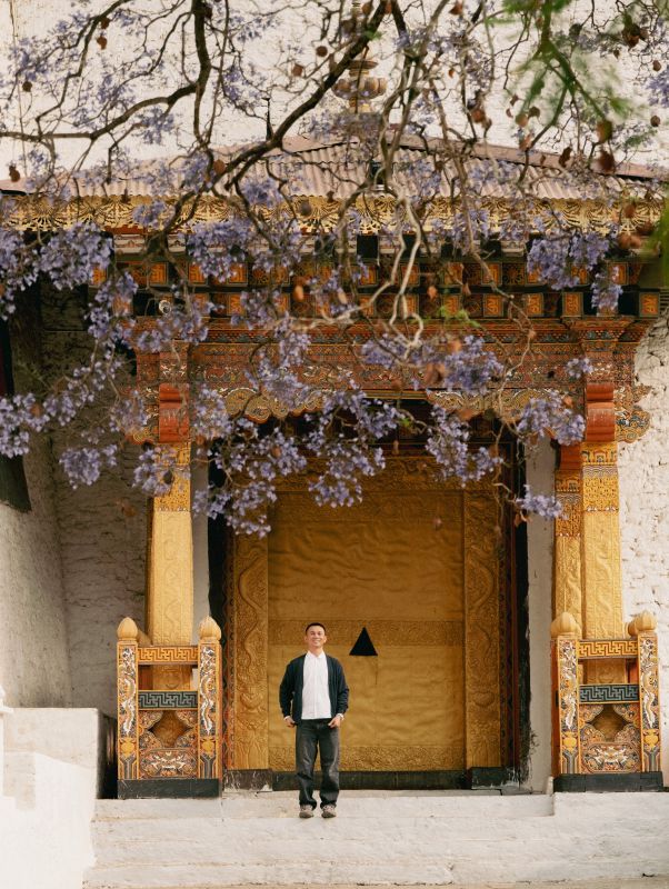 Travel blogger Tâm Bùi tham quan một tu viện giữa mùa phượng tím ở Bhutan. Ảnh: Nhân vật cung cấp
