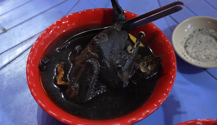 Luke ăn món gà ác hay gà đen tần thuốc bắc trên phố Hàng Cót, Hà Nội. Ảnh: cắt từ clip