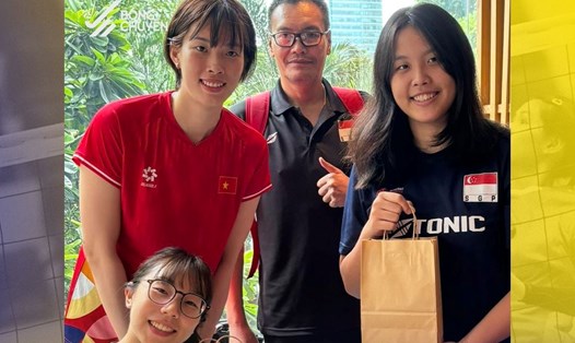 Thanh Thúy thay mặt tuyển bóng chuyền nữ Việt Nam tặng quà cho 2 vận động viên Singapore. Ảnh: Bóng chuyền Việt Nam