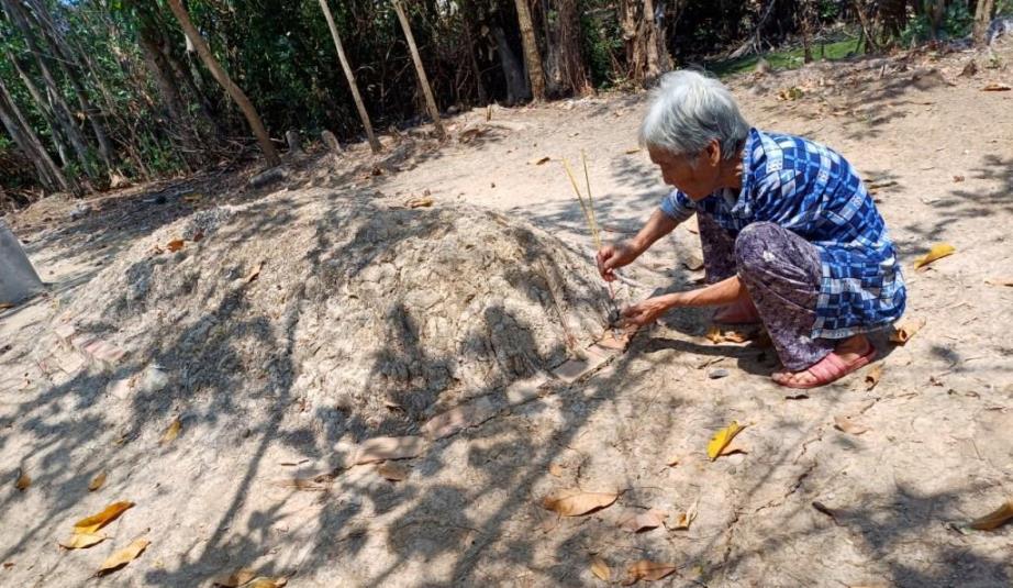Bà Ba bên mộ phần của người chồng. Ảnh: Xuân Nhi