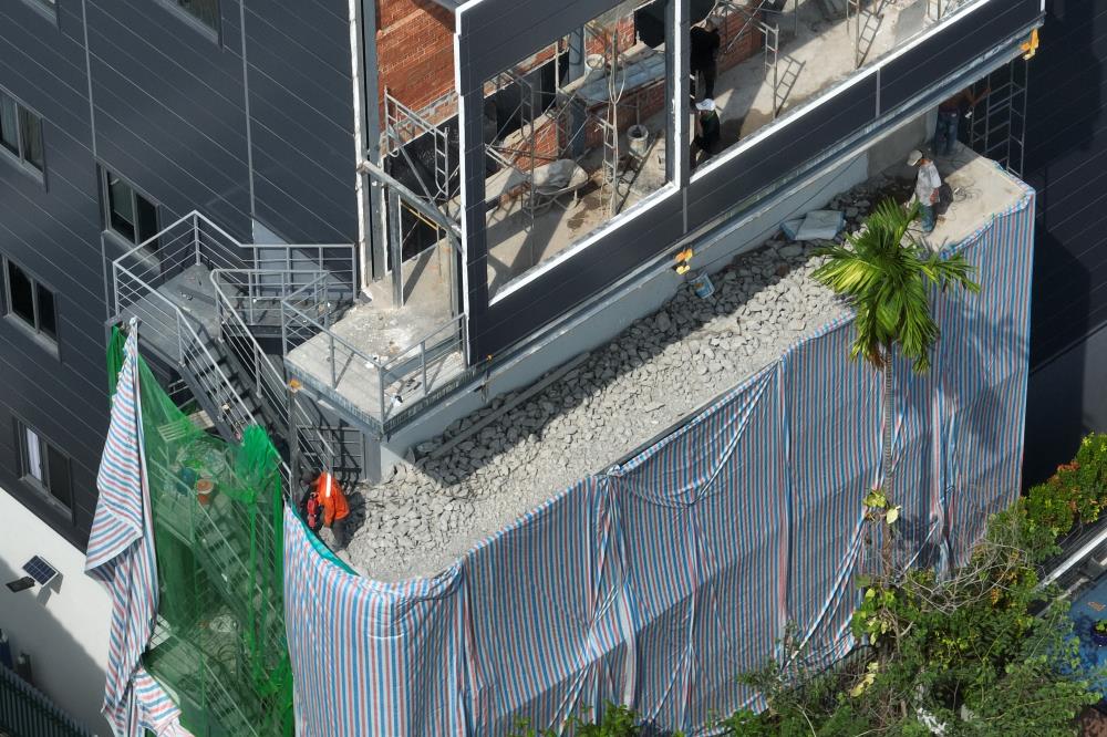 Ban công của công trình một diện tích là 104m2, cầu thang sắt từ tầng 1 đến tầng 4 thuộc phạm vi xây dựng trái phép đang được công nhân khoan phá.