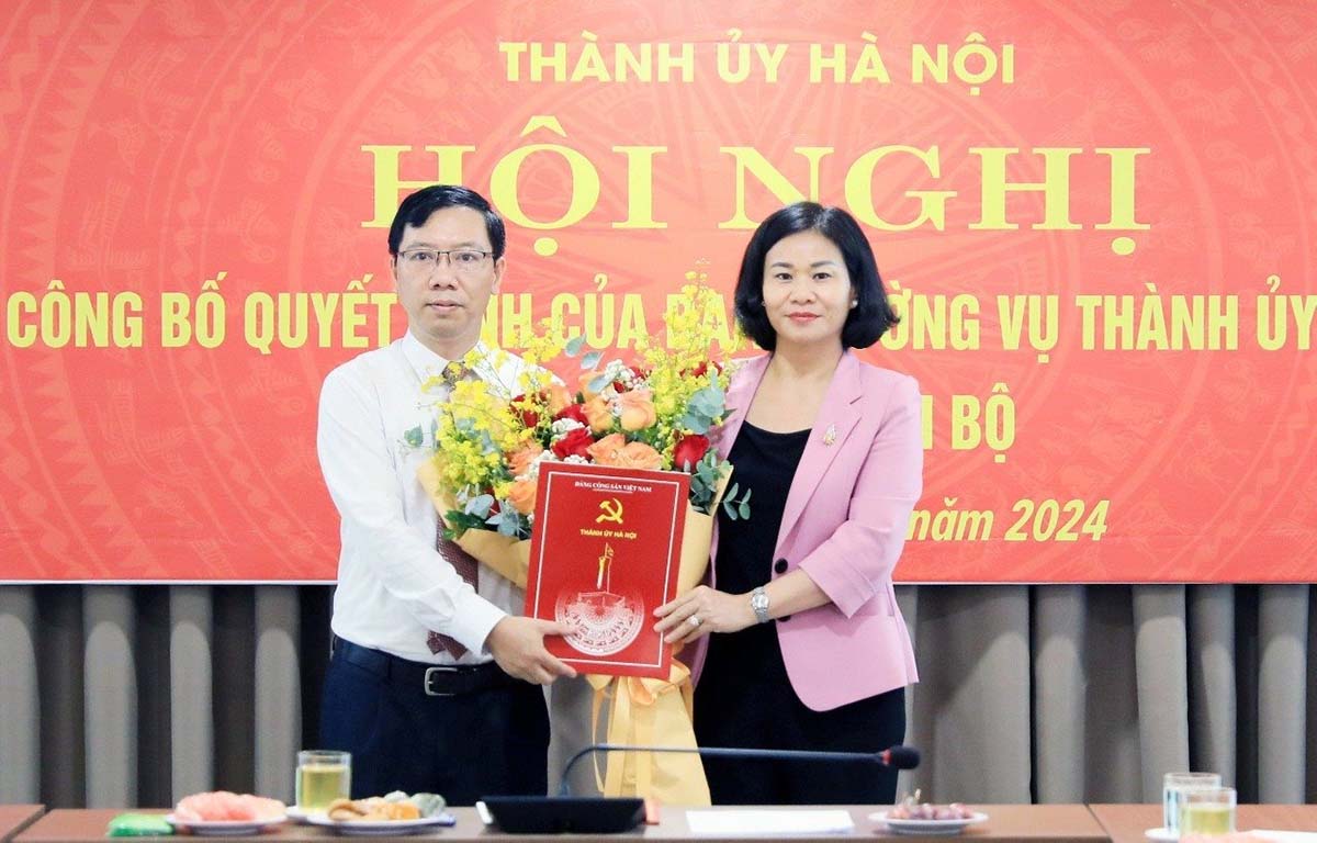 Phó Bí thư Thường trực Thành ủy Hà Nội Nguyễn Thị Tuyến trao quyết định và tặng hoa chúc mừng ông Nguyễn Hoàng Sơn. Ảnh: Quang Thái