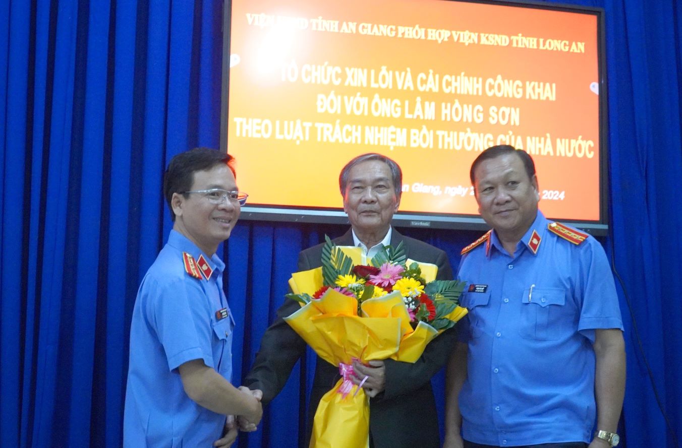 Đại diện Viện Kiểm nhân dân 2 tỉnh tặng hoa chúc mừng ông Lâm Hồng Sơn tại buổi xin lỗi và cải chính công khai. Ảnh: Tháp Mười