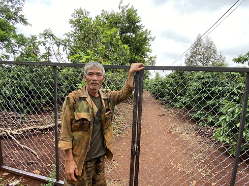 Nông dân Hà Văn Luyến bên cánh cửa sắt ngăn vào thu hoạch sầu riêng. Ảnh: Thanh Tuấn
