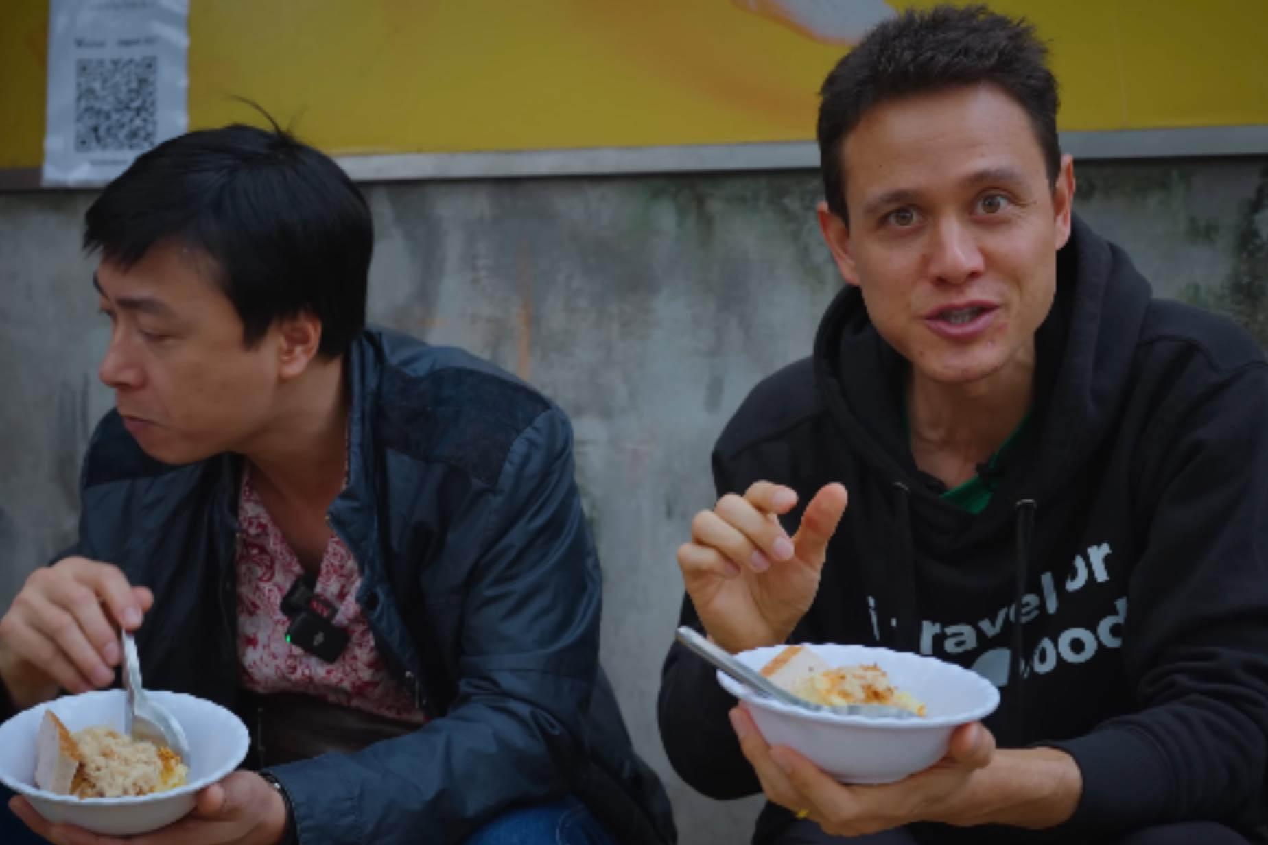 Mark Wiens (phải) trải nghiệm và đưa ra danh sách 5 món ăn đường phố Hà Nội ngon nhất. Ảnh: Cắt từ video