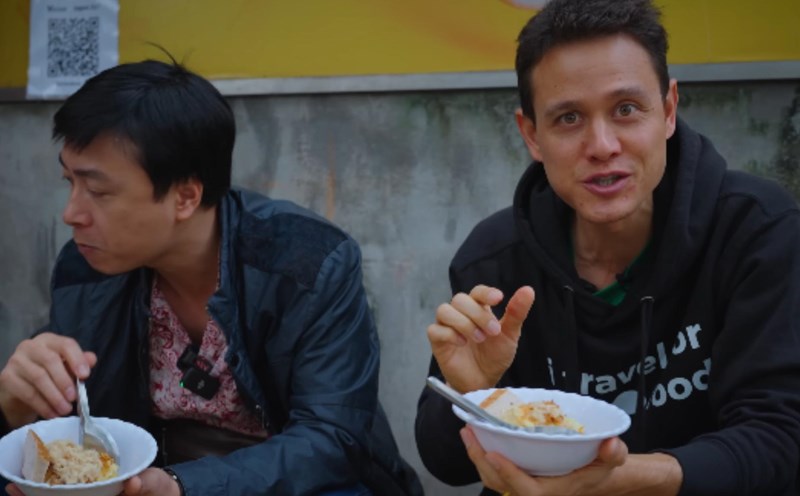 Mark Wiens (phải) trải nghiệm và đưa ra danh sách 5 món ăn đường phố Hà Nội ngon nhất. Ảnh: Cắt từ video
