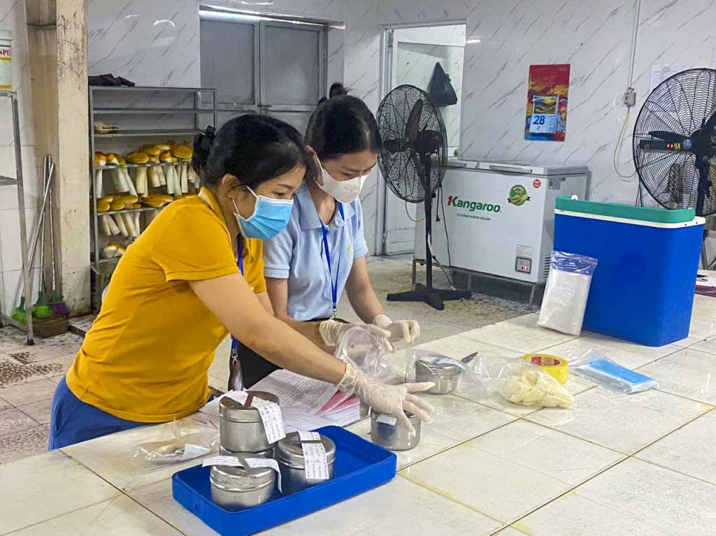 Cán bộ Chi cục An toàn vệ sinh thực phẩm tỉnh Nghệ An lấy mẫu thức ăn để xét nghiệm điều tra nguyên nhân ngộ độc. Ảnh: Hải Đăng.