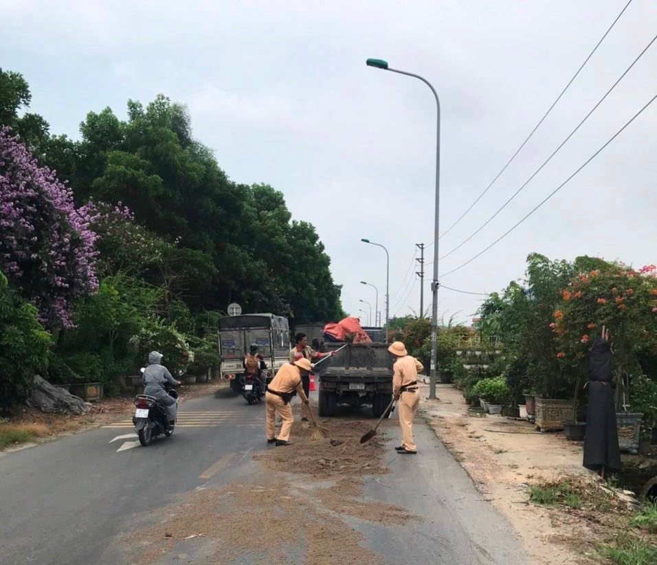 Cảnh sát giao thông khắc phục vết dầu loang trên đường gom Võ Nguyên Giáp (Đông Anh, Hà Nội). Ảnh: Dương Hiệp