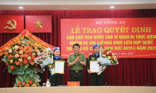 Thượng tướng Lương Tam Quang - Thứ trưởng Bộ Công an trao quyết định của Chủ tịch nước cho 2 sĩ quan công an nhân dân đi thực hiện nhiệm vụ gìn giữ hòa bình. Ảnh: Bộ Công an