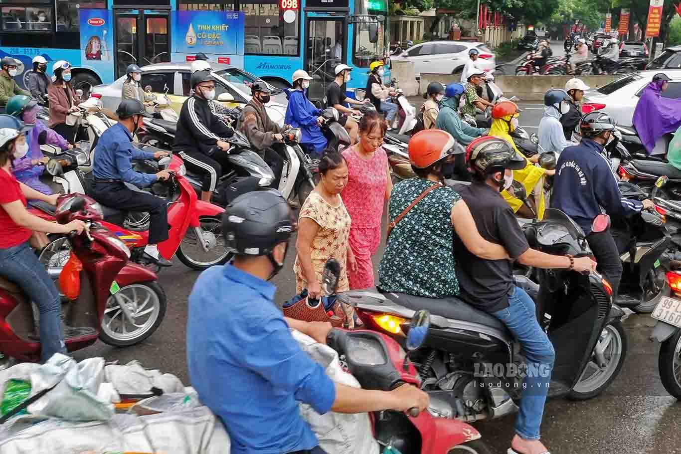 Người đi bộ len lỏi giữa dòng xe. Đến khoảng 8h sáng nay mưa bắt đầu tạnh nhưng tình trạng ùn tắc vẫn tiếp diễn. Ảnh: Thế Kỷ