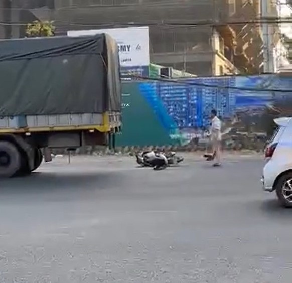 Thi thể nạn nhân nằm ở gần bánh trước xe tải, còn xe máy nằm ở phía sau xe tải bên mé đường Nguyễn Thị Minh Khai. Ảnh: Bạn đọc cung cấp