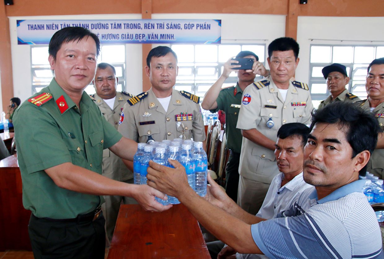 Trung tá Nguyễn Đức Hậu, Trưởng phòng Hậu Cần, Công an tỉnh An Giang  trao tặng nước ngọt đóng chai cho người dân