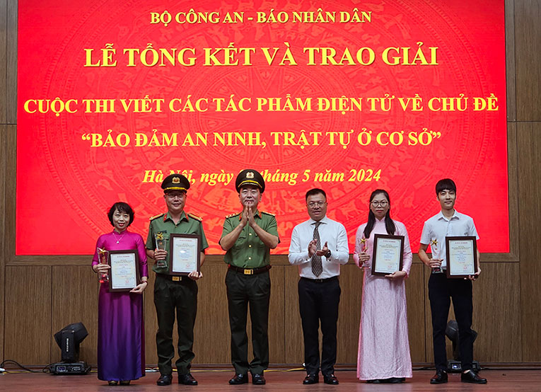 Thượng tướng Trần Quốc Tỏ và ông Lê Quốc Minh (thứ ba, thứ tư từ trái qua) trao giải cho các tác giả đạt giải Nhất. Ảnh: Quang Việt