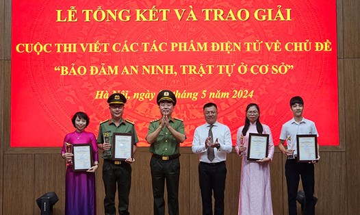 Thượng tướng Trần Quốc Tỏ và ông Lê Quốc Minh (thứ ba, thứ tư từ trái qua) trao giải cho các tác giả đạt giải Nhất. Ảnh: Quang Việt