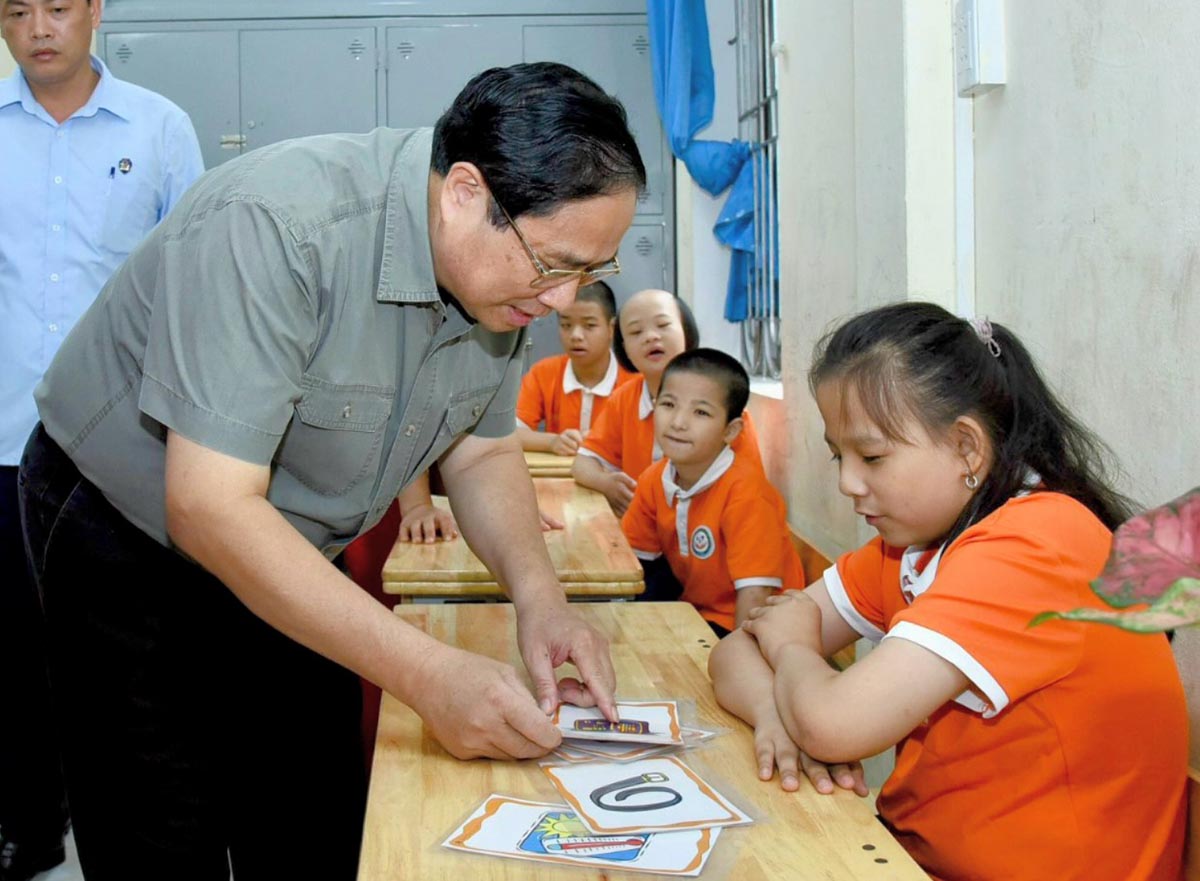 Thủ tướng Chính phủ trò chuyện và cùng các cháu khuyết tật đang học tại Trung tâm tham gia các hoạt động học tập, vui chơi. Ảnh: VGP