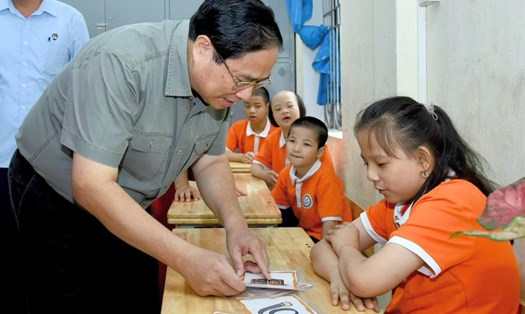 Thủ tướng Chính phủ trò chuyện và cùng các cháu khuyết tật đang học tại Trung tâm tham gia các hoạt động học tập, vui chơi. Ảnh: VGP
