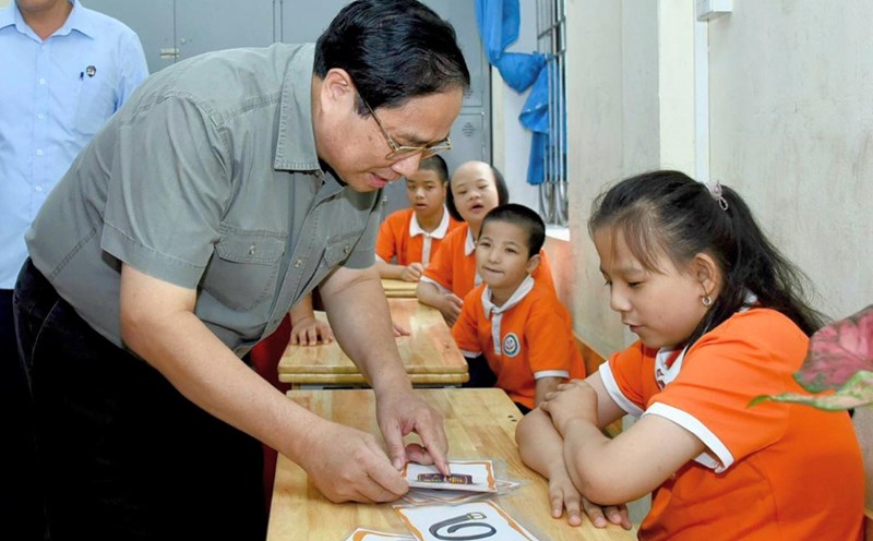 Thủ tướng Chính phủ trò chuyện và cùng các cháu khuyết tật đang học tại Trung tâm tham gia các hoạt động học tập, vui chơi. Ảnh: VGP