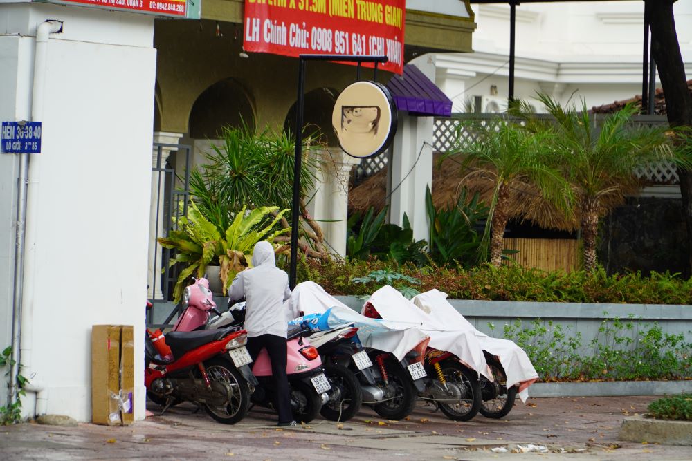 Nhiều xe máy trên vỉa hè đường Trần Quốc Thảo (Quận 3) được phủ áo mưa tránh ướt.