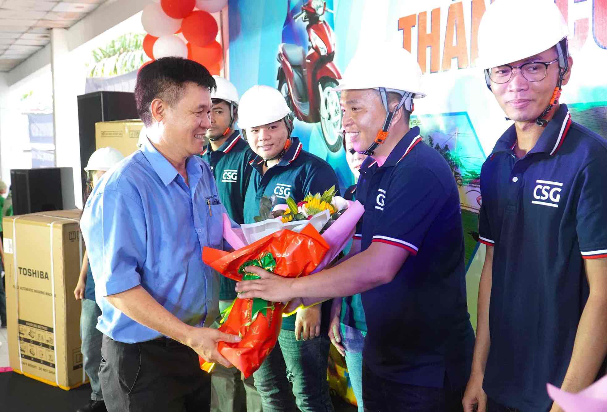 Chủ tịch Công đoàn cơ sở Công ty TNHH Changshin Việt Nam trao hoa chúc mừng Đội tình nguyện viên chuyên sửa nhà cho người lao động. Ảnh: HAC