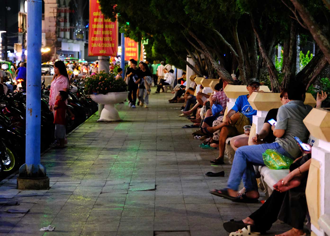 Các băng ghế đá tại phố đi bộ Ninh Kiều chật kín người ngồi. Ảnh: Mỹ Ly